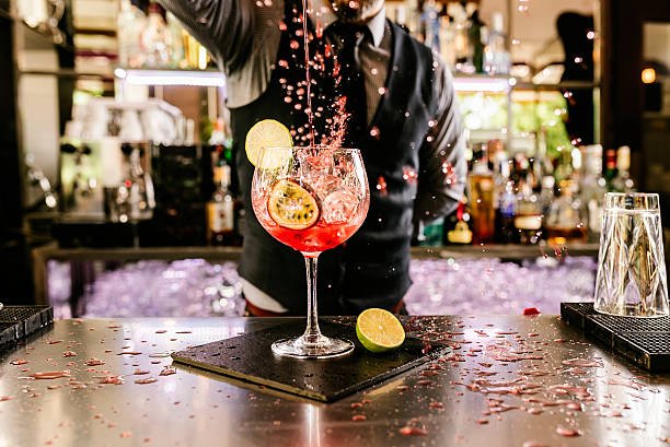 Expert barman is making cocktail at night club.